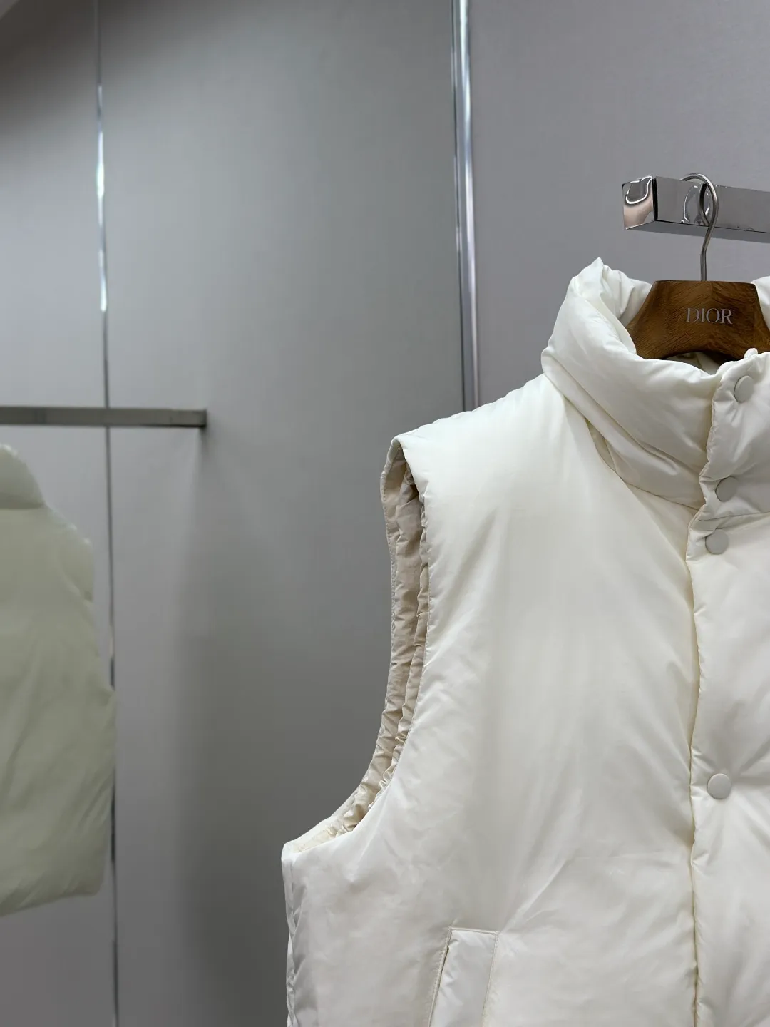 P810 AMIPARIS love padded embroidered down vest Fabric selection: Taffeta fabric woven from 100% polyester fiber. It adopts warp and weft plain weave and is woven very tightly, making the surface of the fabric extremely smooth and flat, with a "skinny" and stiffness that is not easy to collapse. When rubbed or moved around, it will make a unique, crisp "rustling" sound. At the same time, it has a delicate plain texture and a soft, elegant silky luster. This kind of luster is not as dazzling as satin, but more restrained and advanced.  Lining selection: Use 100% nylon to create the lining. The high-density and tight weaving process prevents tiny lint from getting out of the gaps in the fabric. The smooth surface improves the putting on and taking off experience, and the excellent wear and tear resistance ensures damage caused by frequent use, while the light and soft texture does not affect the overall weight.  Technology: The fabric and padding material are tightly fixed on the frame of the embroidery machine. The embroidery machine uses sparse stitches along the padding layer to outline the filling area of the pattern, and then runs the overlay layer's padding, using dense stitches to perfectly cover the foam padding layer, thus forming a slightly raised love embroidery, which feels soft and full, enhancing recognition while maintaining a low profile. High-quality filling: It uses 90 white duck down with a weight of 160g to ensure excellent thermal insulation performance. After strict screening and processing, the velvet is not easy to get drilled, ensuring durability.  Accessories: One-to-one customized three-standard, one-to-one customized hem elastic buckle, one-to-one customized snap button SIZE: XS S M L